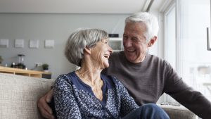 Laughing senior couple sitting together on the couch in the living room