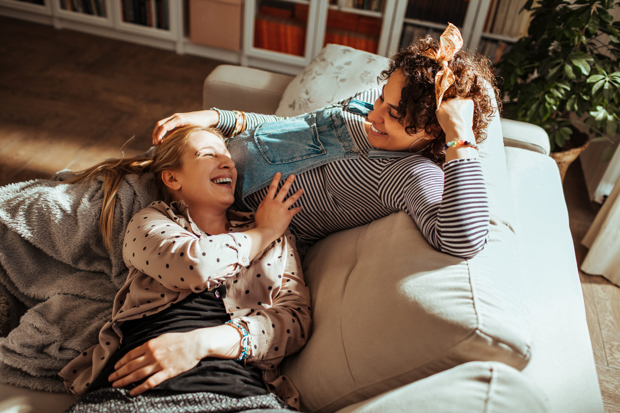 Una mujer acaricia la barriga de su pareja embarazada.