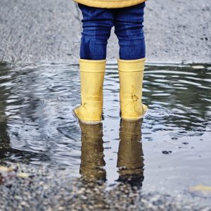 una niña está de espaldas sobre un charco