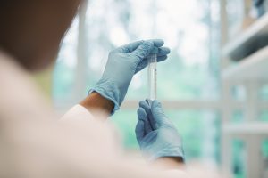 Una investigadora examina un tubo de ensayo.