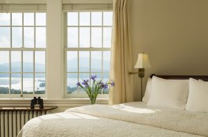 Cama hecha, limpia y ordenada en una habitación con vistas al mar.