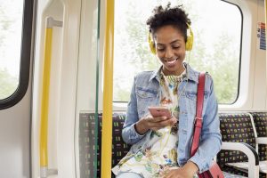 Una joven escucha música en el metro mientras comprueba qué frases poner en su próximo publicación de Instagram.