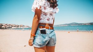 woman  in jeans shorts with the phone in pocket