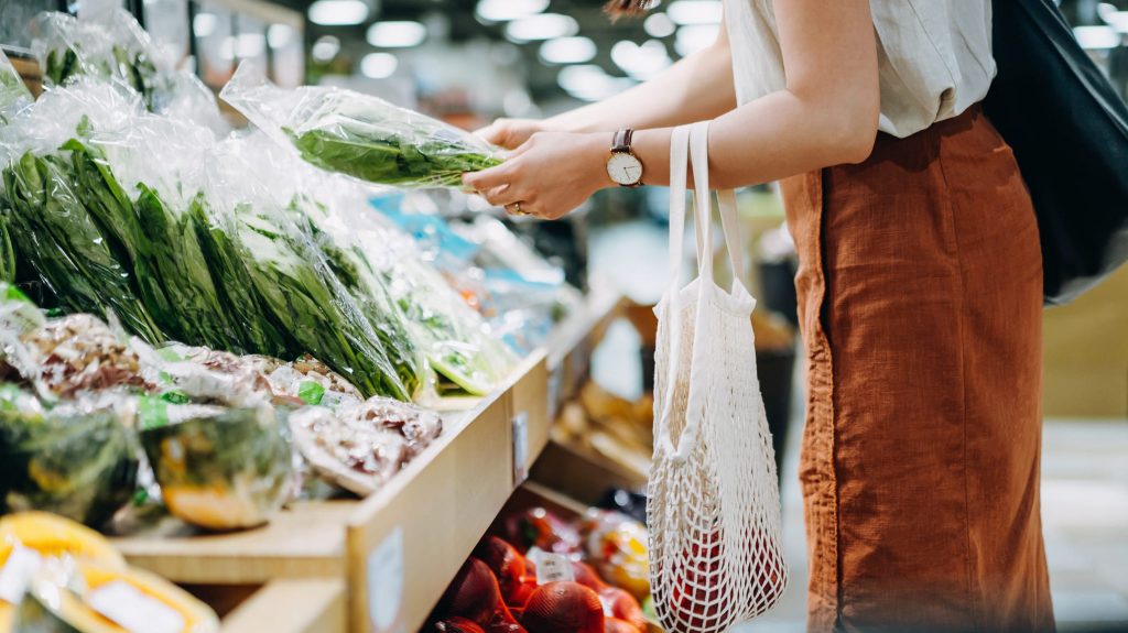 Una mujer compra frutas y verduras en el supermercado.