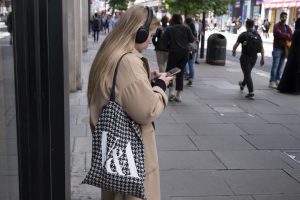 Una chica joven consulta su red social en plena calle.