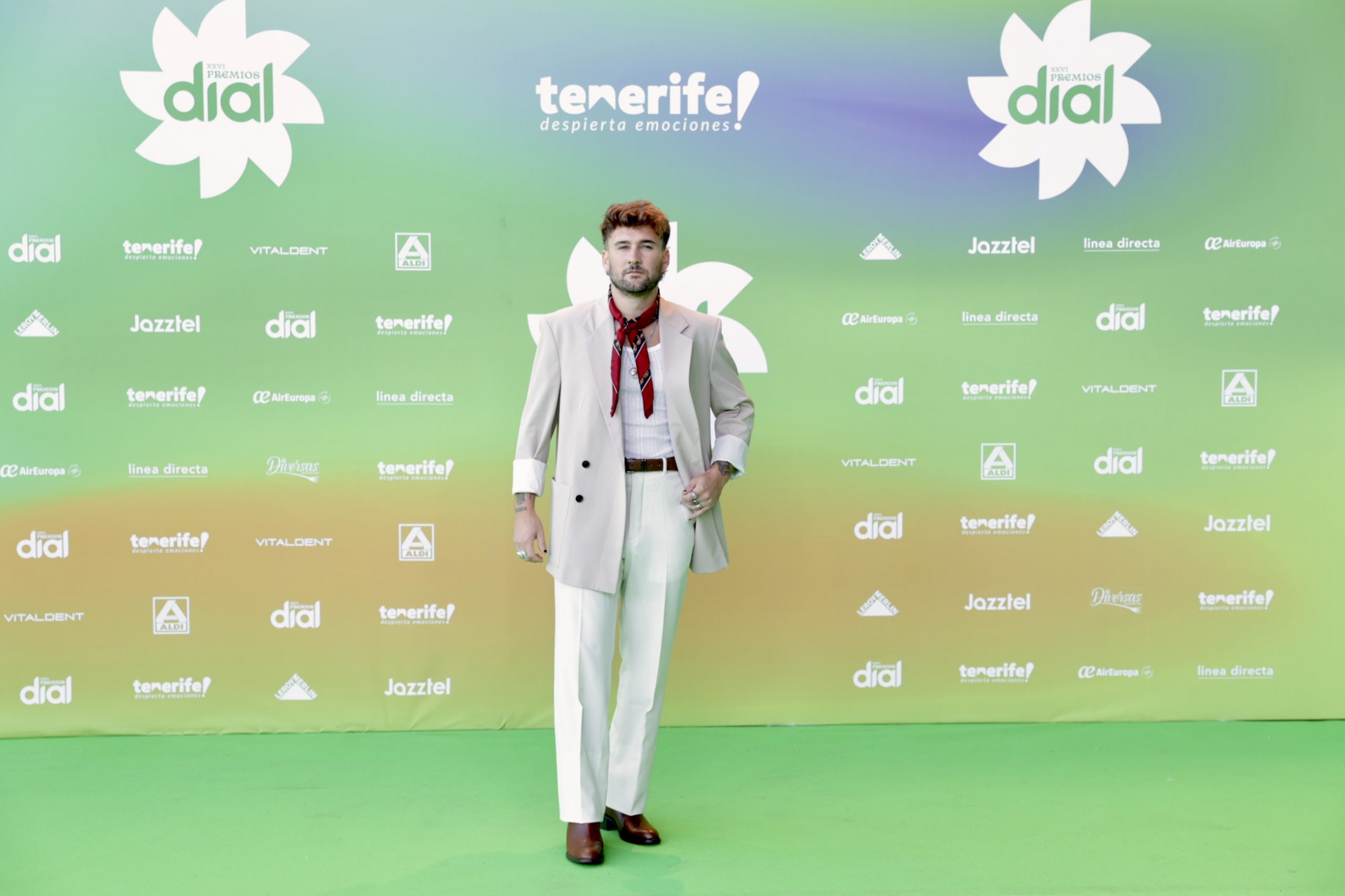 El cantante Dani Fernández luce un traje blanco que contrasta con un pañuelo y una americana en tonos granates.