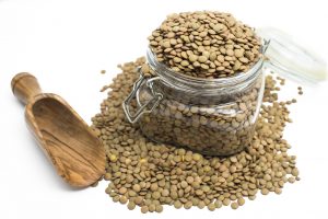 Un tarro de cristal lleno de lentejas crudas.