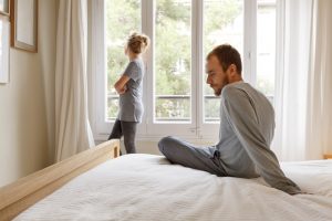 Mid adult couple in bedroom, having disagreement