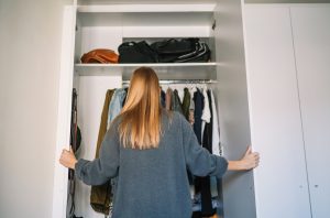 Una chica trata de poner orden a su armario.