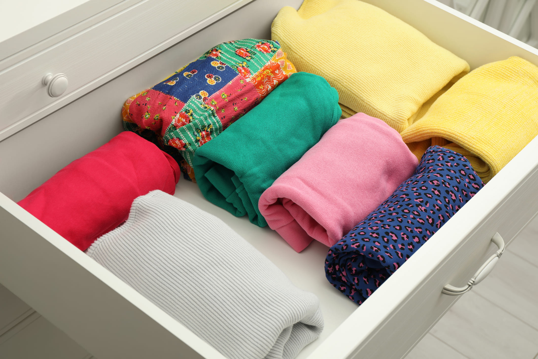 Varias prendas de ropa dobladas en un cajón.