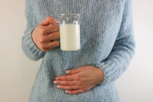 Una chica se toca el estómago tras tomar leche.