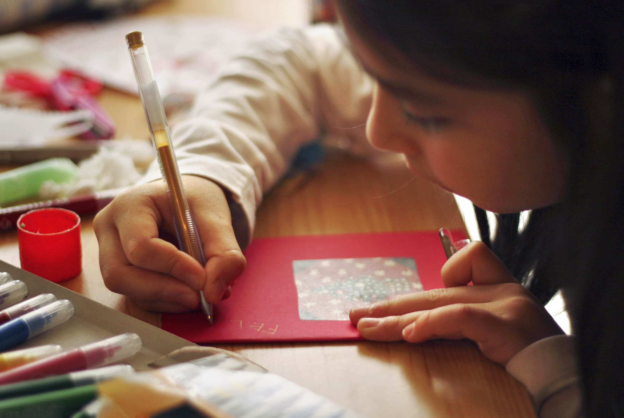 Una niña pinta sobre una cartulina.