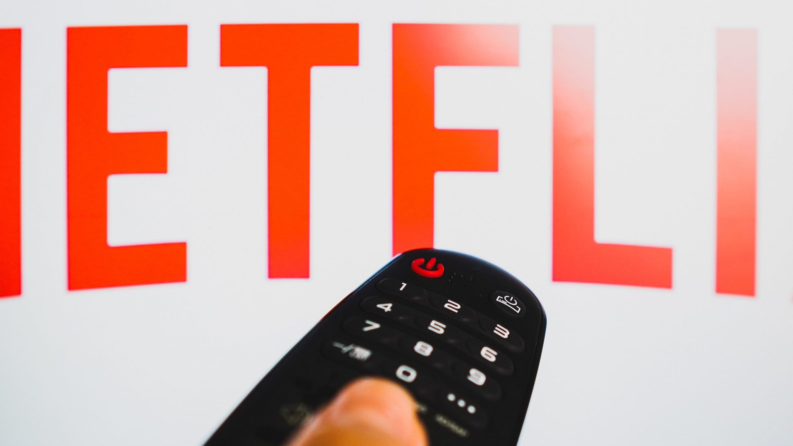 Un usuario pulsa el botón en el mando a distancia para abrir Netflix en su televisor.
