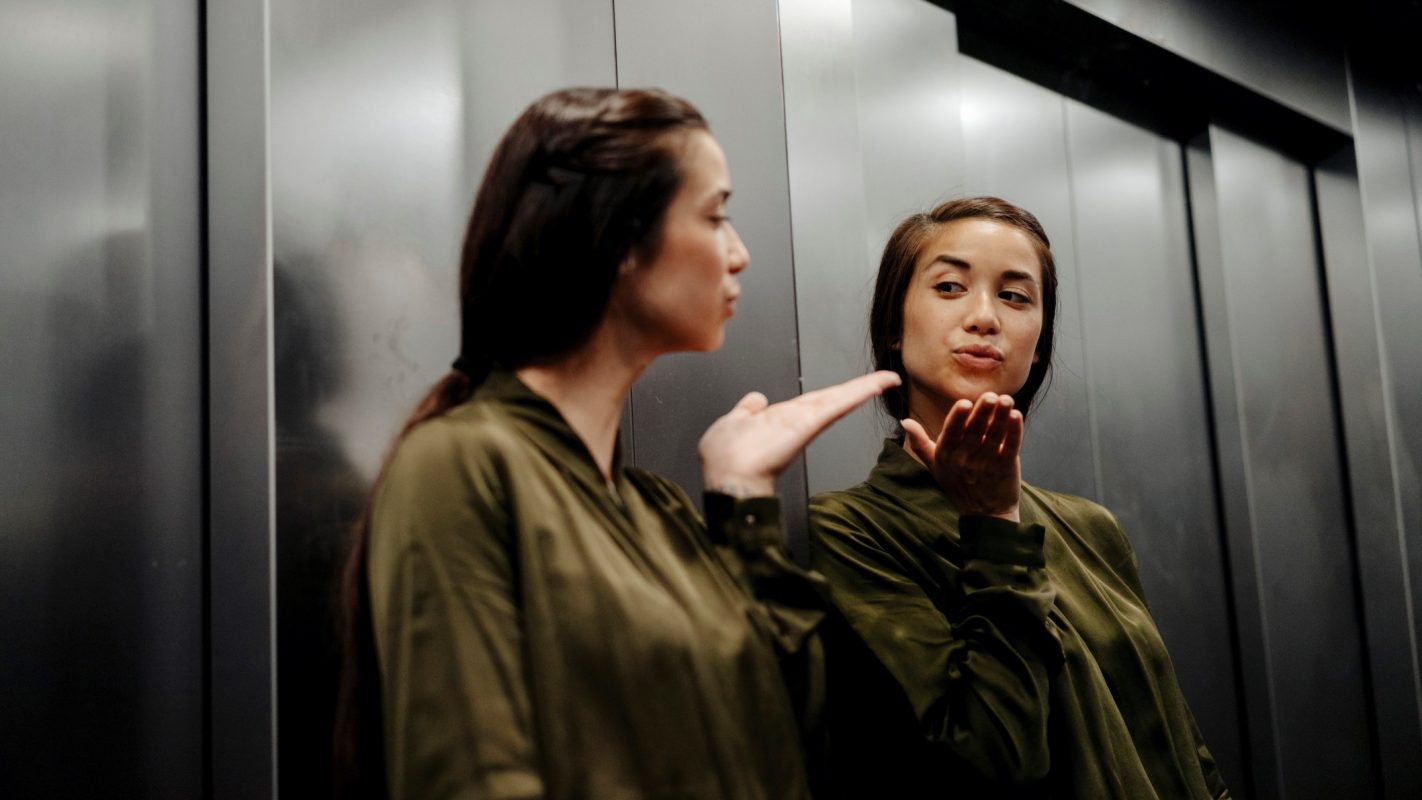 Una persona narcisista se mira al espejo.