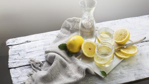 Lemon water on white wooden table. Still life.