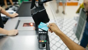 Close up of a hand paying with a credit card in a supermarket