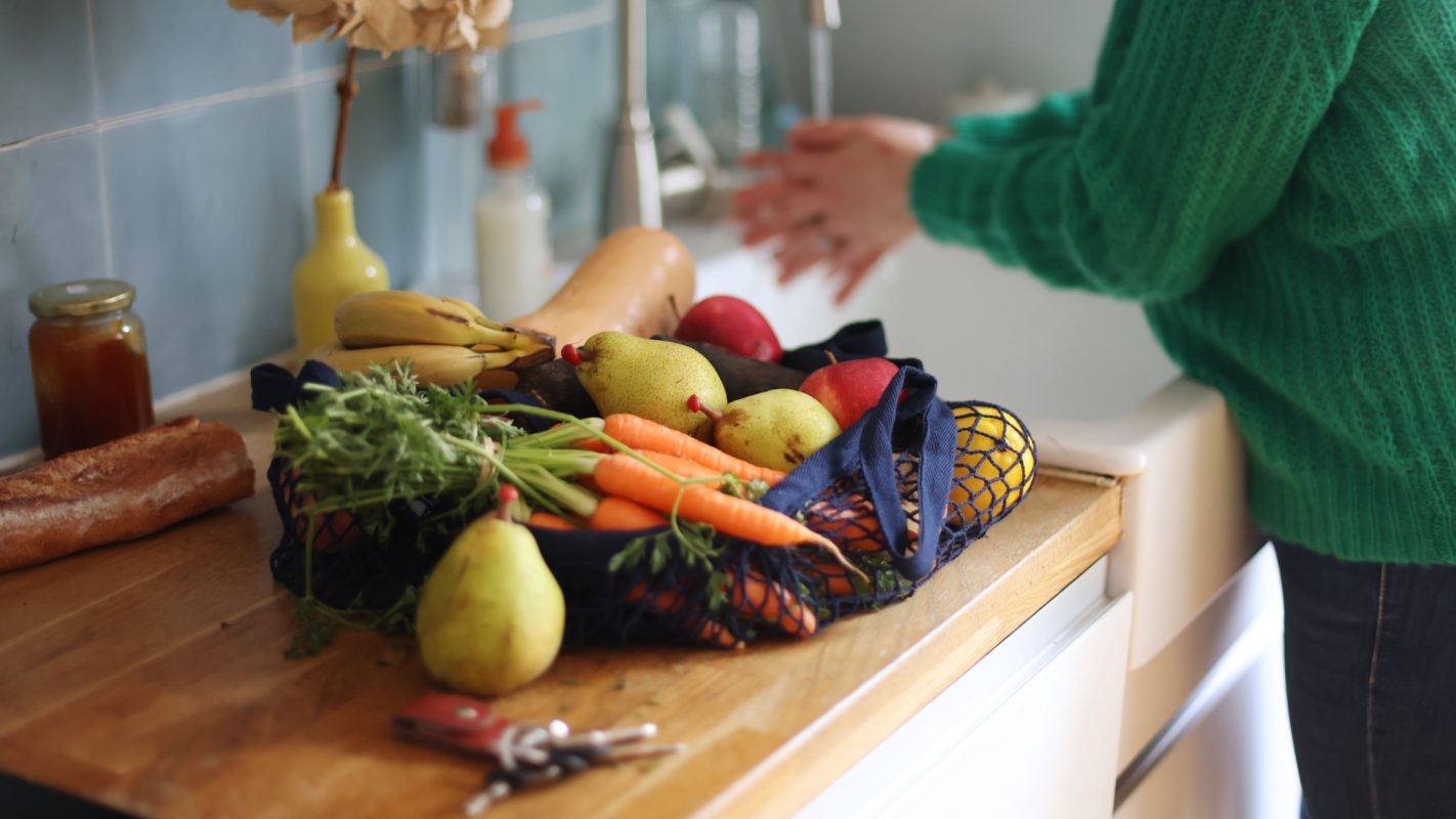 Una mujer lava las frutas y verduras que acaba de comprar.