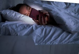 Una mamijama pendiente del móvil a mitad de la noche por si recibe una llamada de sus hijos.