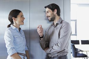 Una chica charla con alguien de su trabajo muy animadamente.