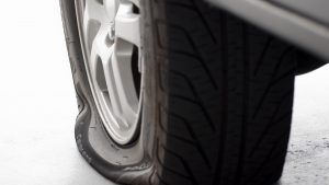 A flat tire is the focus isolated on white