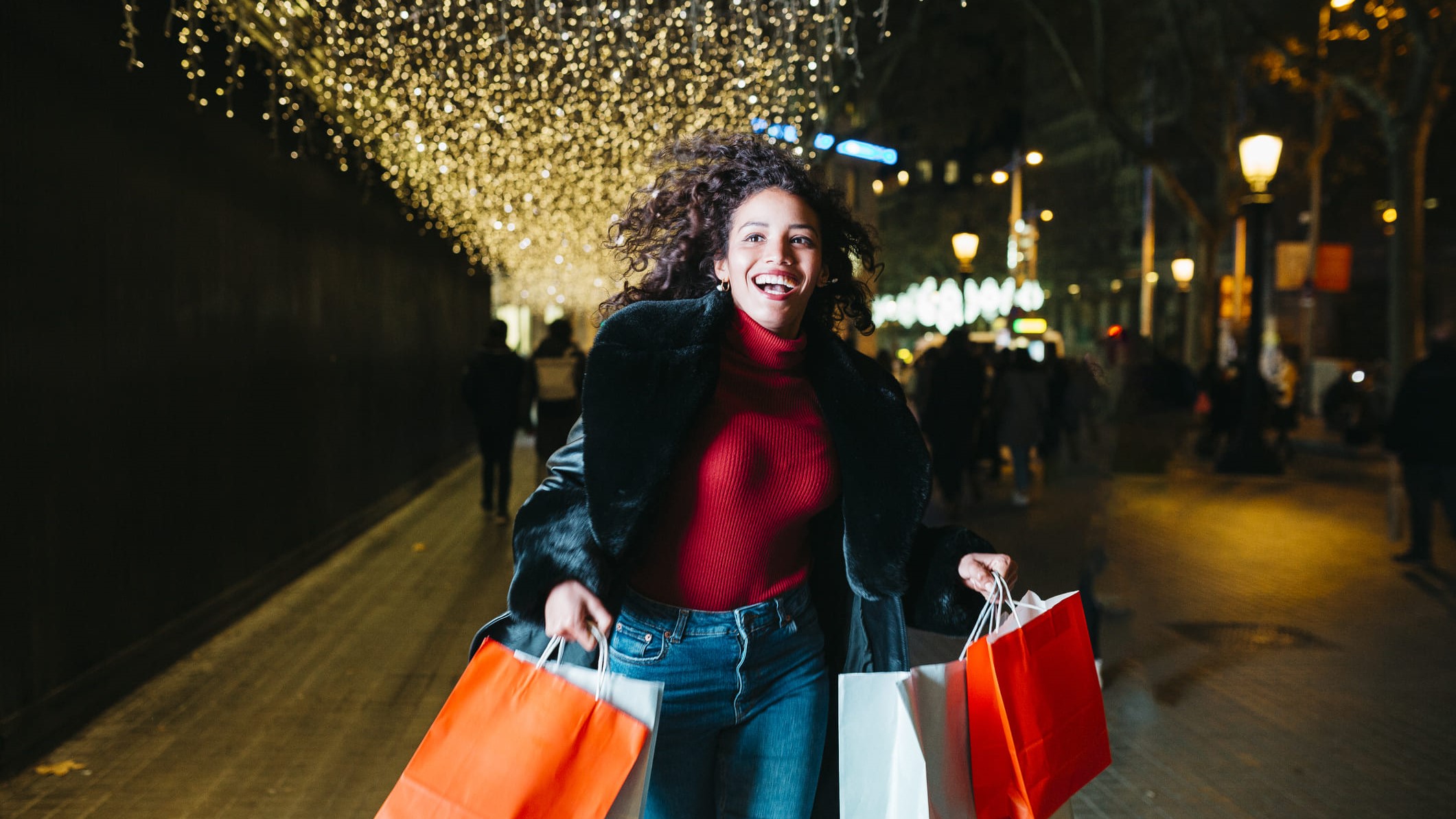 Una chica carga con todas las bolsas de los regalos navideños.