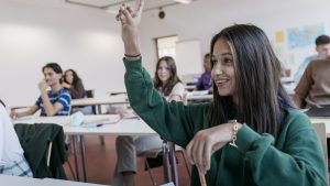 High School Student Raising Her Hand In Class