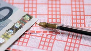 Close-Up Of Sports Betting Ticket, Euro Bills And Pen