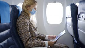 Woman wearing mask inside airplane