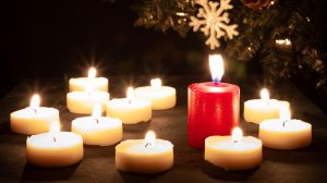 Many White Candles Ond One Red Candle. Bokeh And Flares