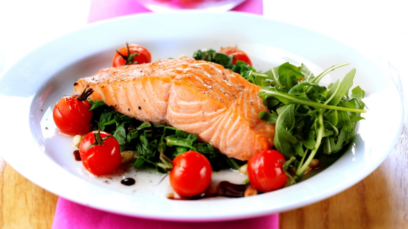 Un plato rico de grasas saludables con salmón y verduras.