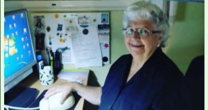 Concha posa sentada frente al ordenador con un enorme ratón y una sonrisa.