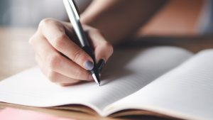 Una persona escribe a mano en una libreta.