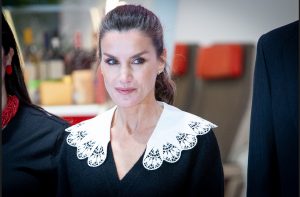 Reina Letizia con un jersey babero y mirando lo que sucede a su alrededor.