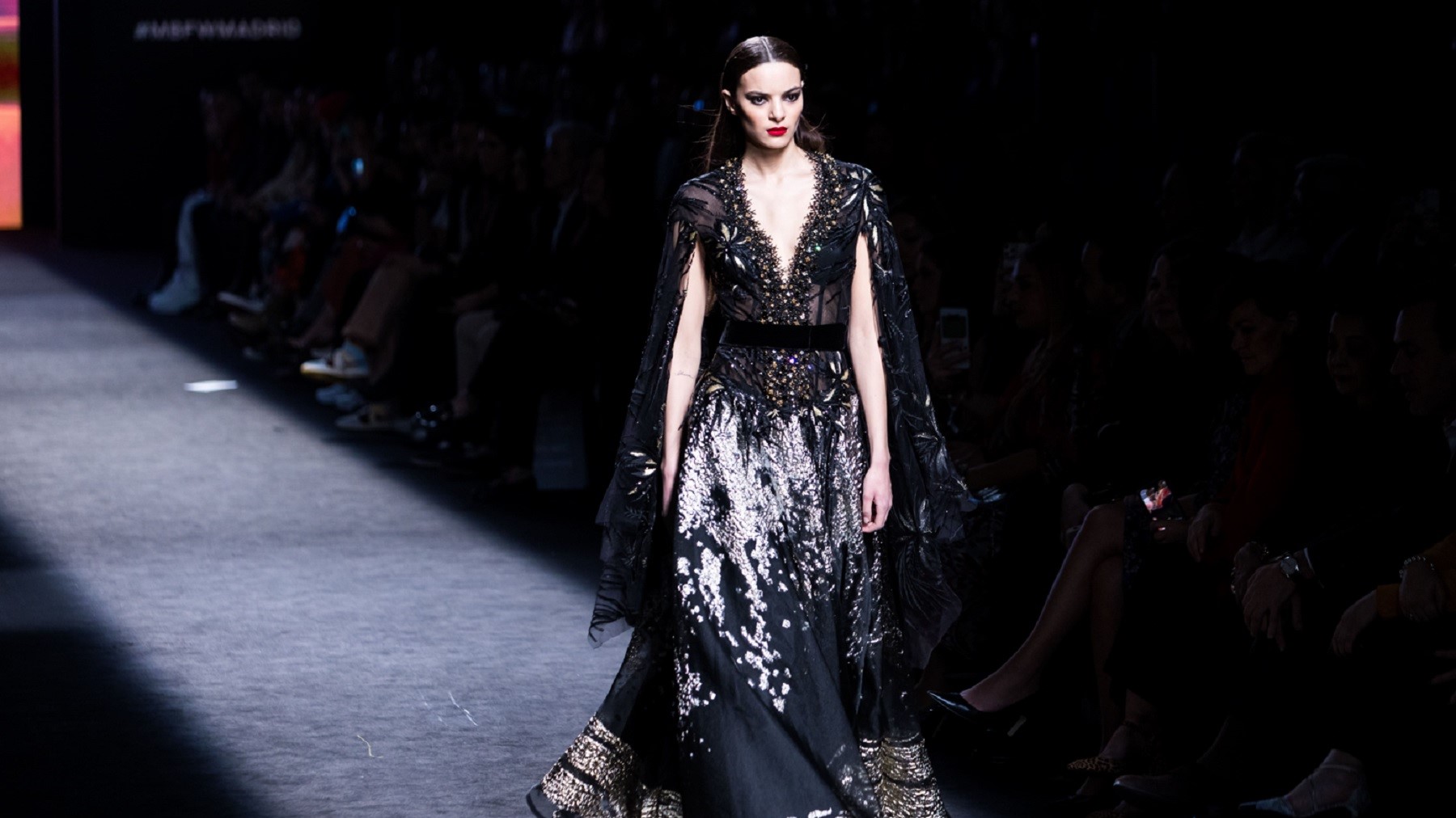 Una modela desfila con un traje negro y con toques lenceros en la Madrid Fashion Week.