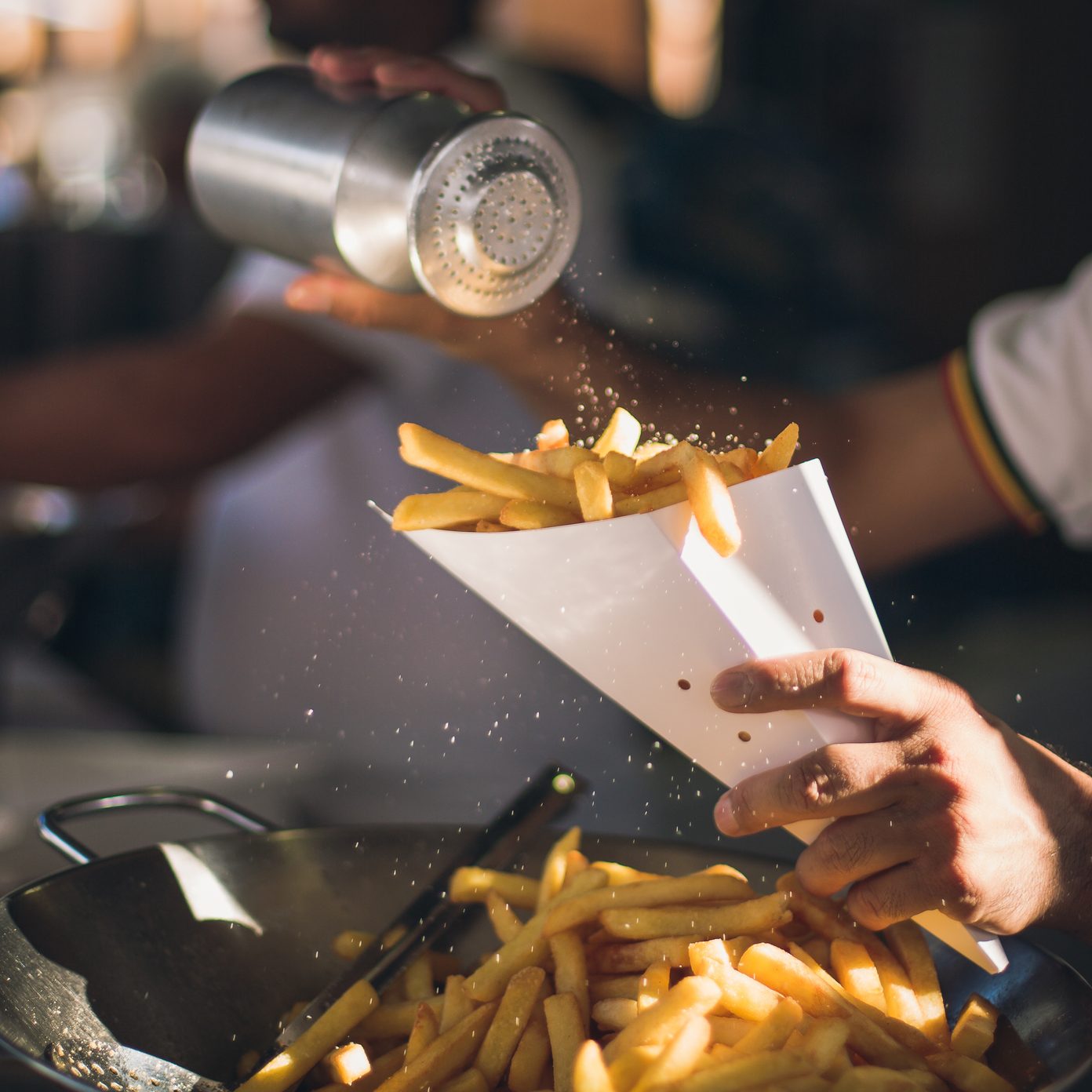 Alguien echa sal en las patatas fritas.