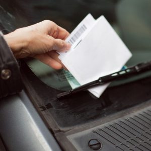 Close-up of human hand taking parking ticket from car