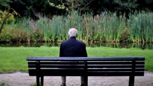 Senior man sitting on bench in garden