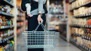 Cropped shot of mother carrying a shopping cart, doing grocery shopping in supermarket