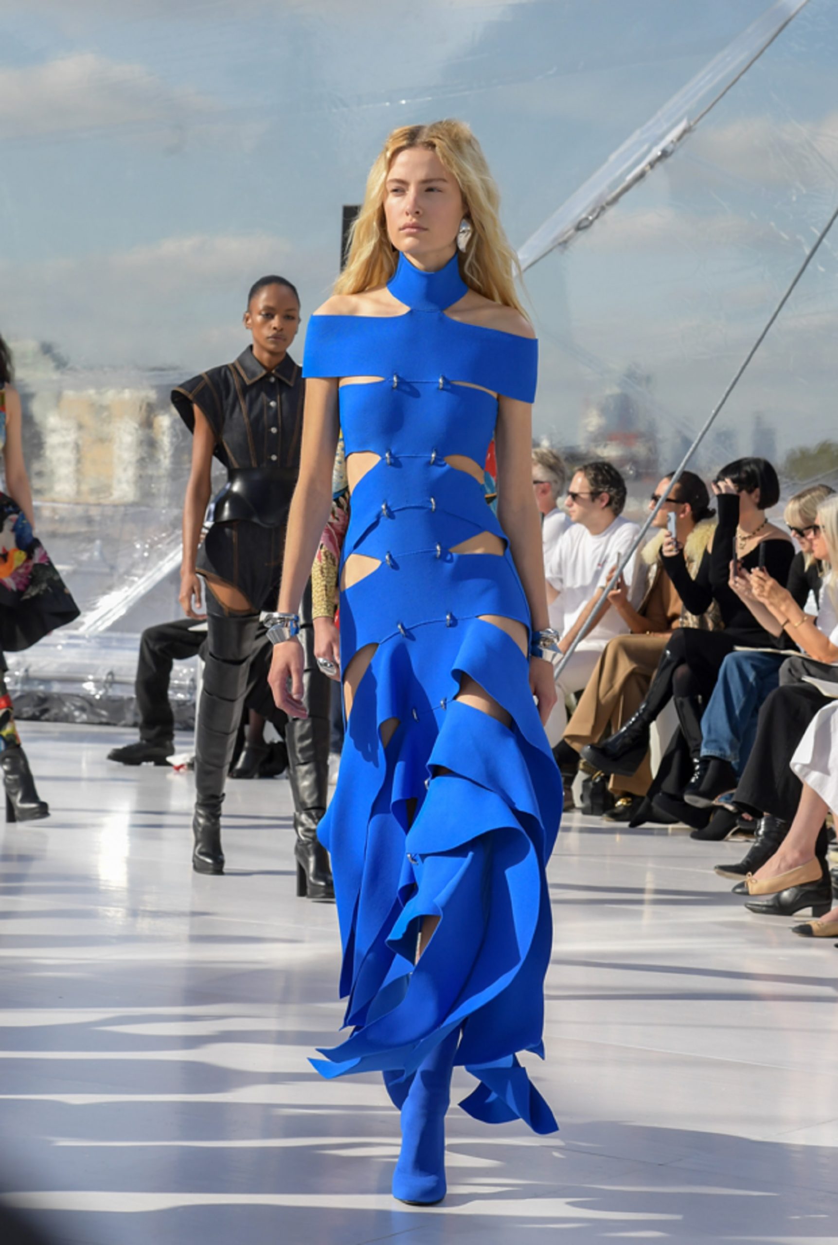 Una modela llevando un vestido azul cobalto de la firma Alexander McQueen.