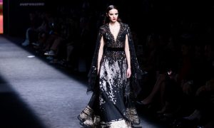 Una modelo desfila en la Madrid Fashion Week con un traje con toques lenceros negros.