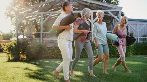 Cheerful group of senior women talking after exercise outdoors in park.