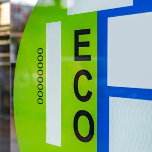 Big green eco electric vehicle label on electric car dealership window. Concept: sustainable and clean transport