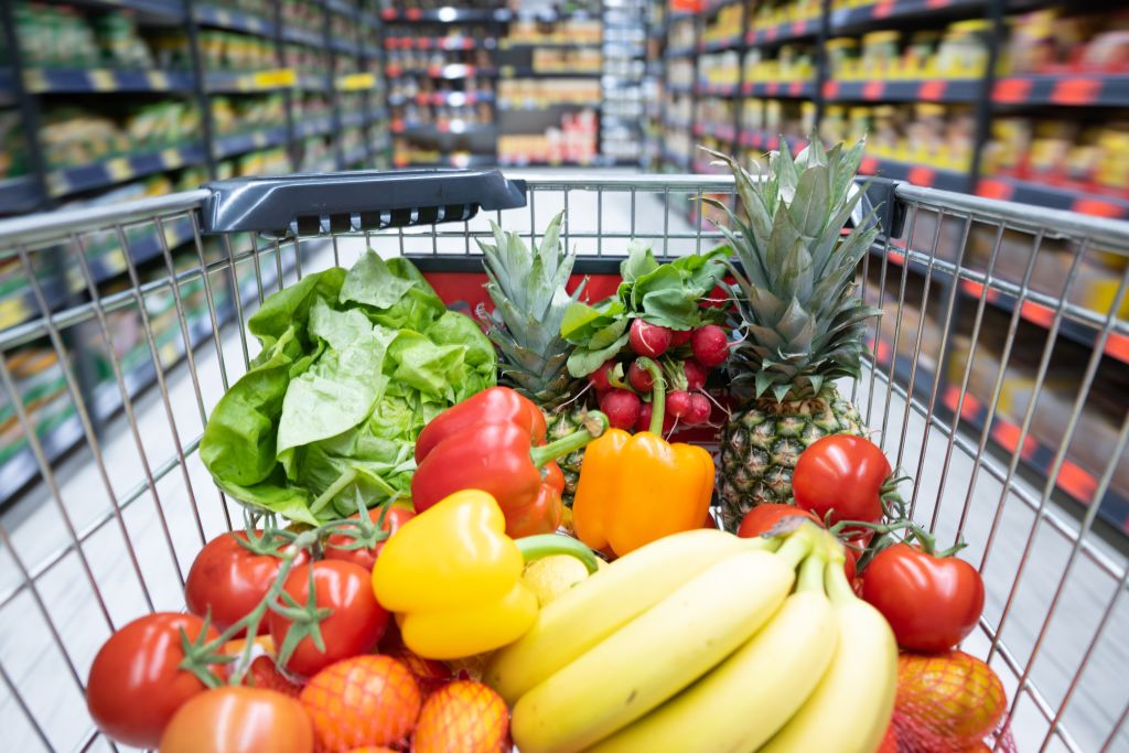 Frutas y verduras dentro de un carro de la comrpa en el supermercado.