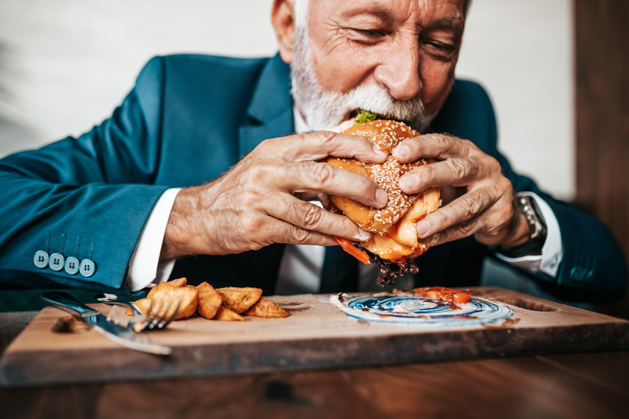 Un hombre comiéndose una irresistible hamburguesa.
