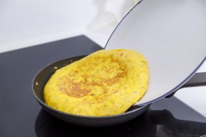 Una tortilla de patatas haciéndose en la sartén.