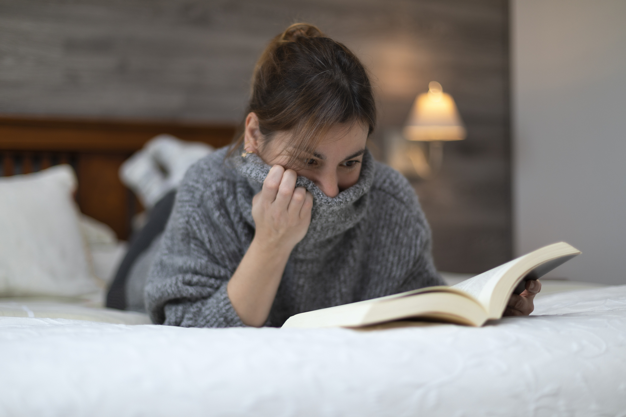 Una chica leyendo el libro en la cama.