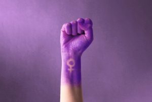 Puño morado de una mujer reivindincanco el movimiento feminista.