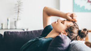 Una mujer cansada se tumba en el sofá