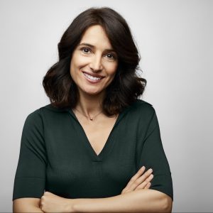 Smiling brunette businesswoman with arms crossed