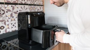 Una chico comprobando cómo funciona la freidora de aire.